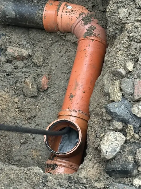 Prace w studzience kanalizacyjnej — czyszczenie odpływów